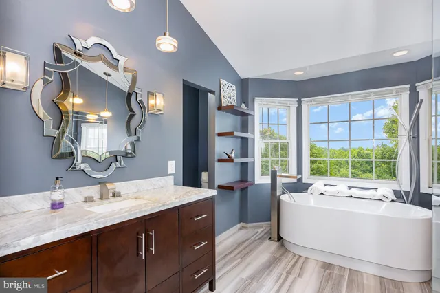 a spacious bathroom with a double vanity sink a mirror and a bathtub