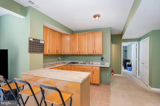 a view of a kitchen with kitchen island a sink a counter top space and a refrigerator