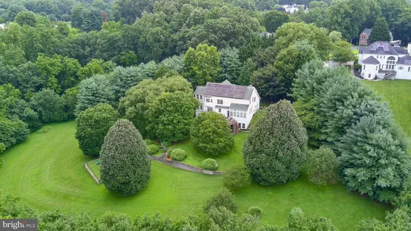 an aerial view of residential house with outdoor space and trees all around