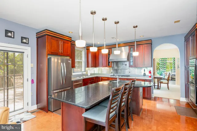 a kitchen with stainless steel appliances granite countertop a table chairs and a large window