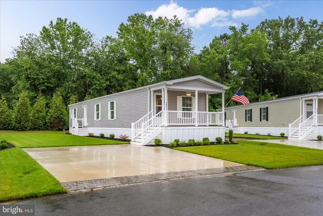 a front view of multi story residential apartment building and car parked on street