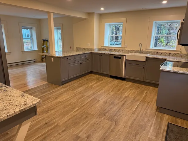 a large kitchen with lot of cabinets and wooden floor