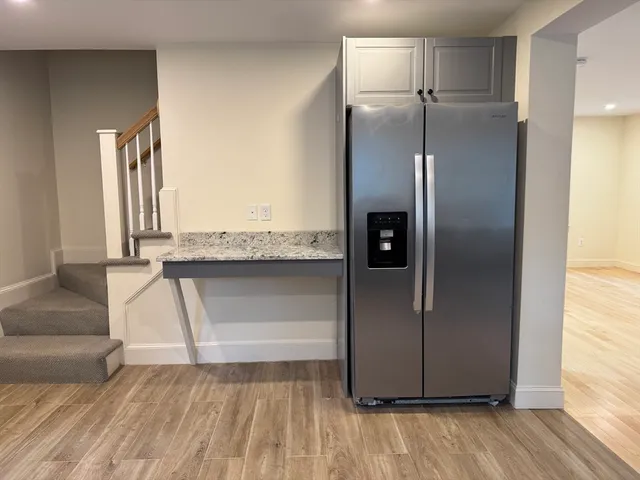 a kitchen with granite countertop a refrigerator and a sink