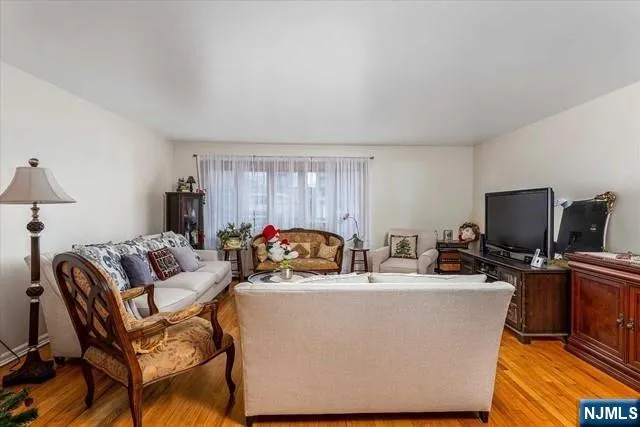 a living room with furniture a flat screen tv and a window