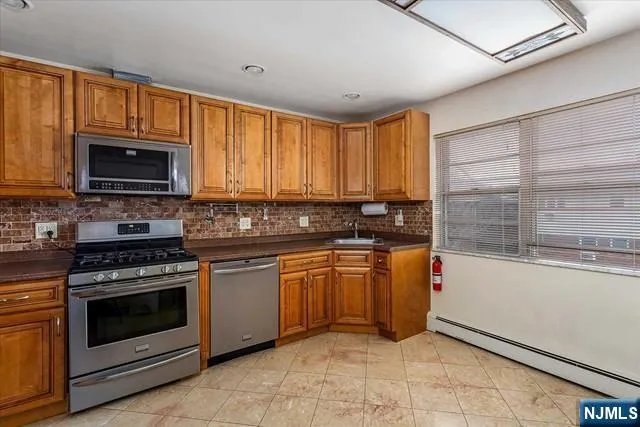 a kitchen with stainless steel appliances granite countertop a stove sink and microwave