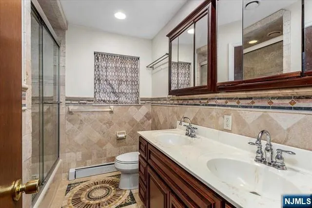 a bathroom with a sink a toilet and a mirror