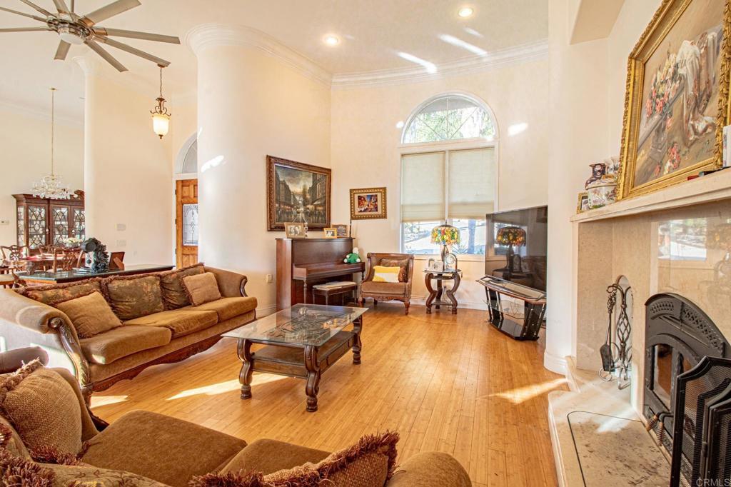 2057 Via Rancho Parkway Escondido, CA 92029 - Photo 12 of 56 a living room with furniture a fireplace and a chandelier