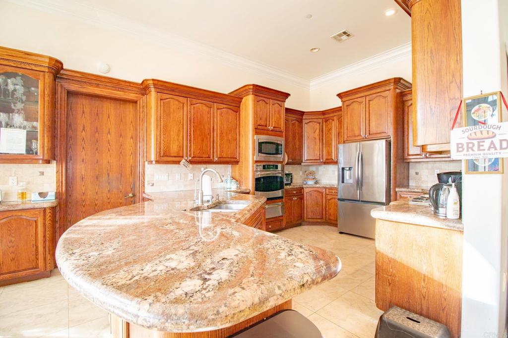 2057 Via Rancho Parkway Escondido, CA 92029 - Photo 18 of 56 a view of a kitchen with kitchen island granite countertop a refrigerator and a stove