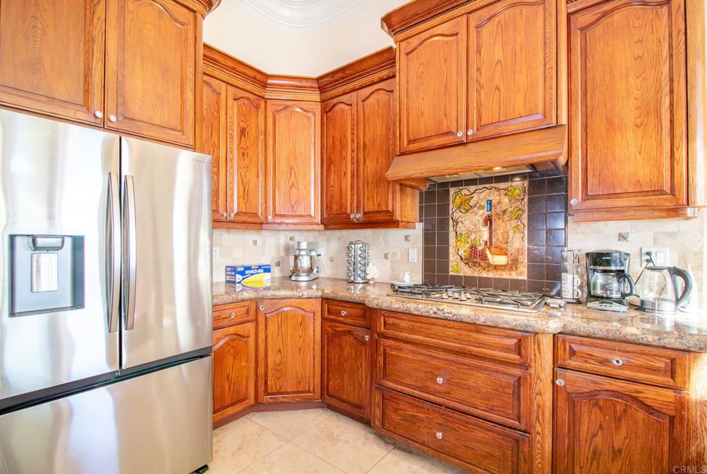 2057 Via Rancho Parkway Escondido, CA 92029 - Photo 19 of 56 a kitchen with stainless steel appliances granite countertop a sink a refrigerator and cabinets