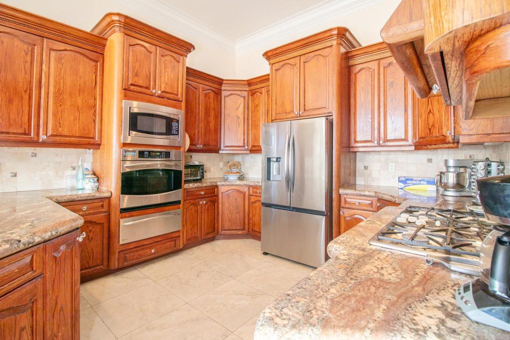 2057 Via Rancho Parkway Escondido, CA 92029 - Photo 20 of 56 a kitchen with stainless steel appliances granite countertop a refrigerator stove and sink