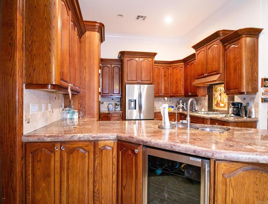 2057 Via Rancho Parkway Escondido, CA 92029 - Photo 21 of 56 a kitchen with sink a refrigerator and cabinets