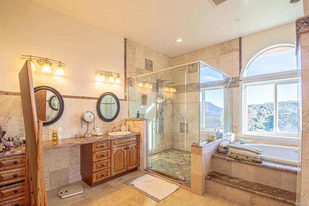 2057 Via Rancho Parkway Escondido, CA 92029 - Photo 24 of 56 a spacious bathroom with a mirror a sink and a mirror