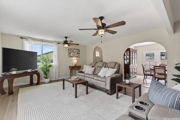 a living room with furniture a flat screen tv and a large window