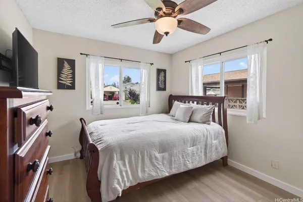 a bedroom with a bed and a flat tv screen on dresser
