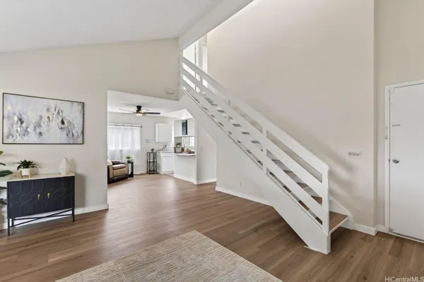a view of a livingroom with wooden floor and stairs