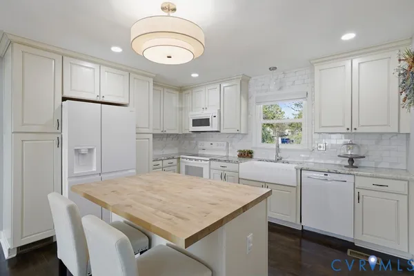 a kitchen with stainless steel appliances granite countertop a sink a stove a refrigerator a center island and cabinets