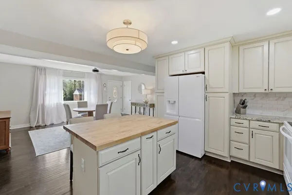 a kitchen with white cabinets and wooden floor