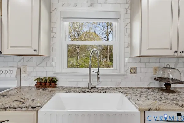 a kitchen with granite countertop a sink and a stove