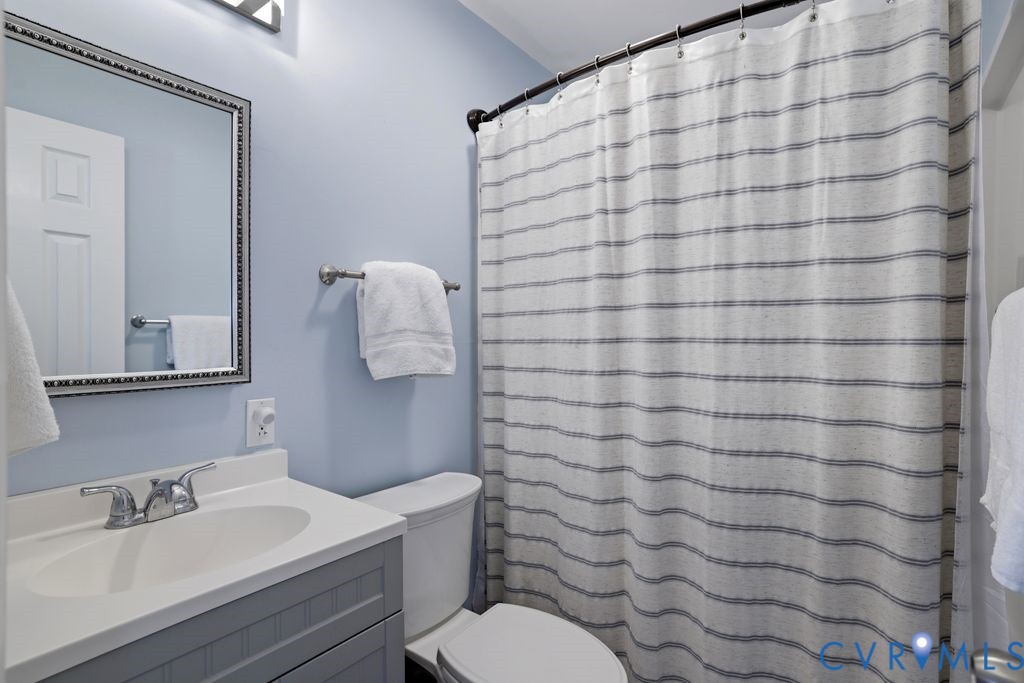 2831 Delfin Road Midlothian, VA 23112 - Photo 22 of 30 a bathroom with a sink a toilet and shower curtain