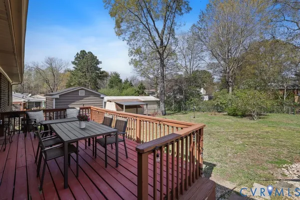a view of a roof deck with table and chairs with wooden floor and fence