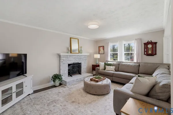 a living room with furniture a flat screen tv and a fireplace