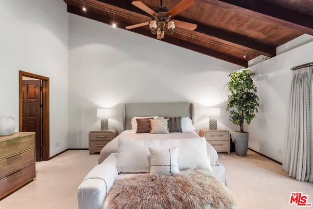 a bedroom with a large bed and a potted plant