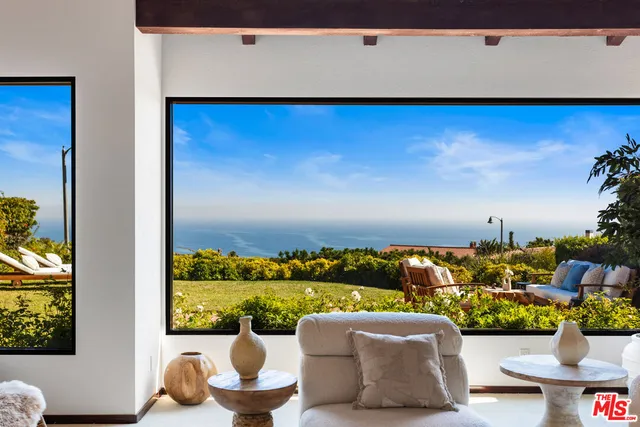 a view of a balcony with couches and potted plants