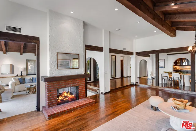 a living room with fireplace furniture and a wooden floor