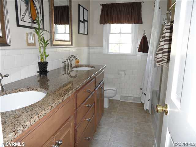 11401 Rochelle Road Chester, VA 23831 - Photo 9 of 12 a bathroom with a granite countertop sink a toilet and a window