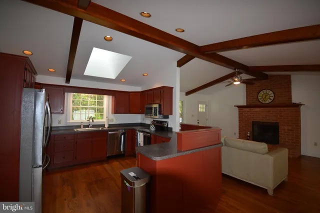 a kitchen with stainless steel appliances granite countertop a refrigerator a stove top oven a sink and dishwasher