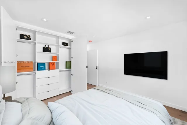 a bedroom with a bed and a flat screen tv
