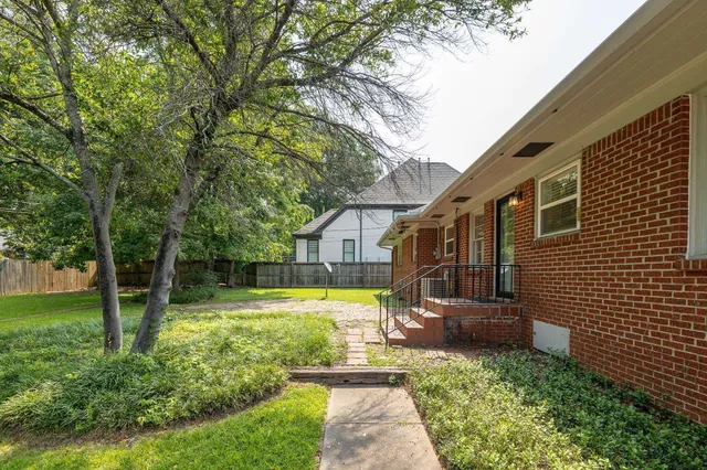 a view of a house with backyard and sitting area