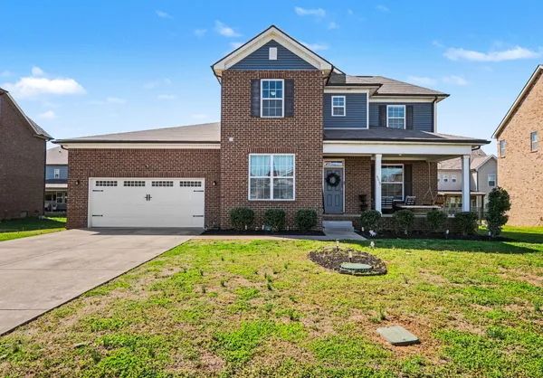 a front view of a house with yard and garage