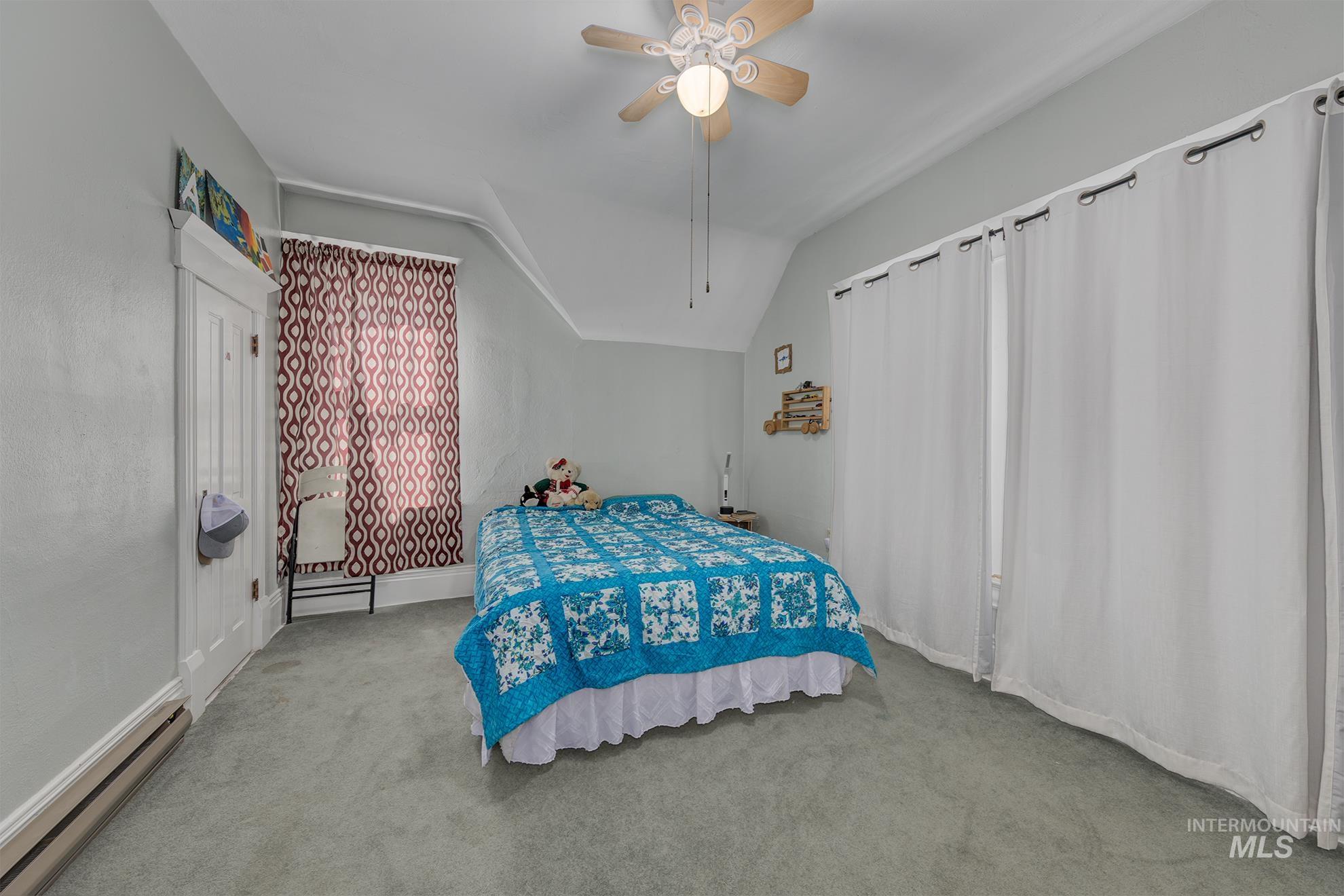 6040 Adams Road New Plymouth, ID 83655 - Photo 31 of 50 Bedroom featuring carpet flooring, baseboard heating, lofted ceiling, and a ceiling fan