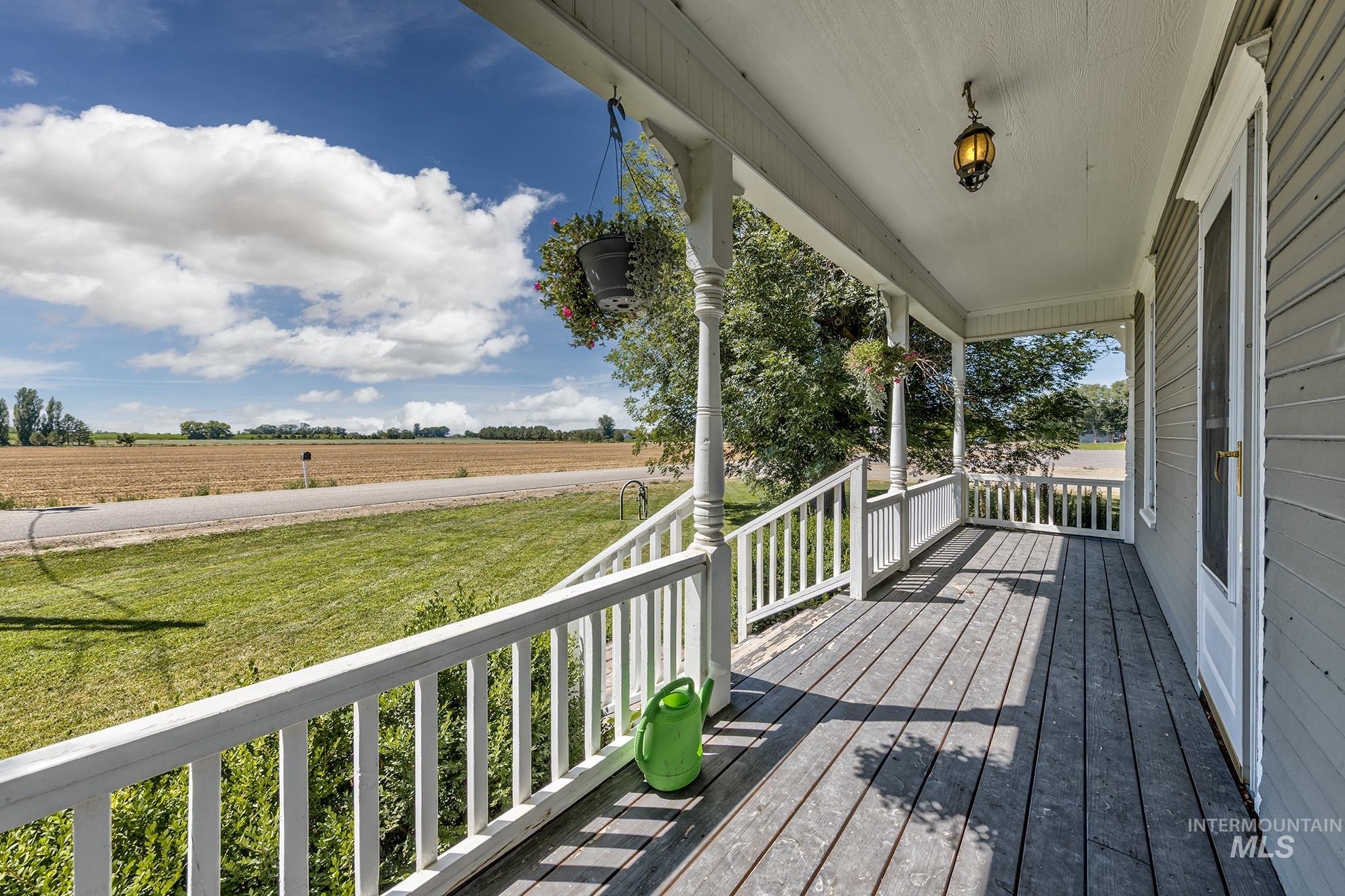 6040 Adams Road New Plymouth, ID 83655 - Photo 9 of 50 Wooden porch with a view of rural / pastoral area and a yard