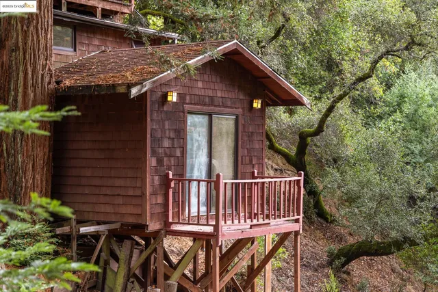 a view of a house with wooden deck and furniture
