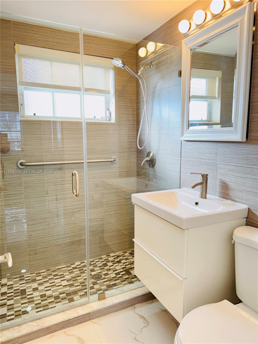 617 Southwest 11th Street, Unit 14E Miami, FL 33129 - Photo 12 of 16 a bathroom with a sink toilet and shower