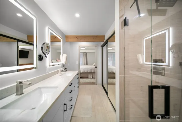 a spacious en suite bathroom with a double vanity sink and a large mirror