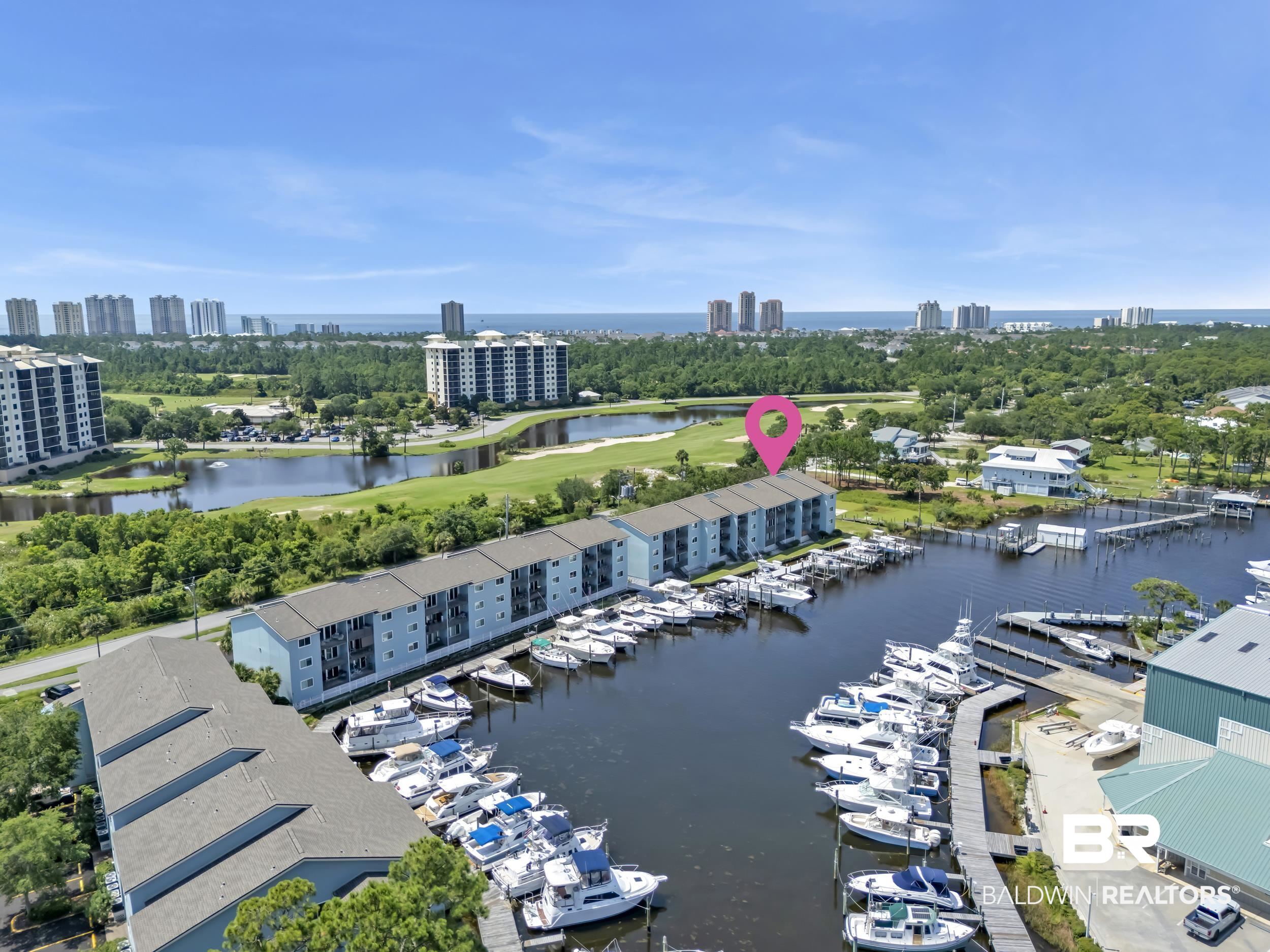 14100 River Road, Unit 211 Pensacola, FL 32507 - Photo 55 of 56 Waterfront property featuring multiple boat slips, marina access, and a golf course backdrop