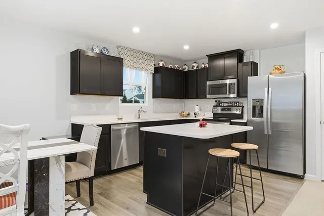 a kitchen with kitchen island a appliances dining table and chairs