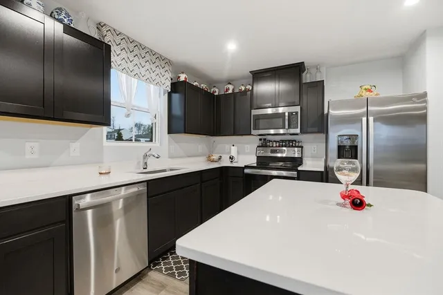 a kitchen with a sink stainless steel appliances and cabinets