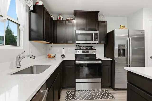 a kitchen with a sink and stainless steel appliances