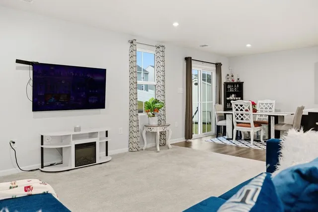 a living room with furniture a flat screen tv and a fireplace