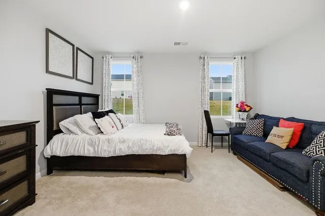 a bedroom with a bed couch and a window