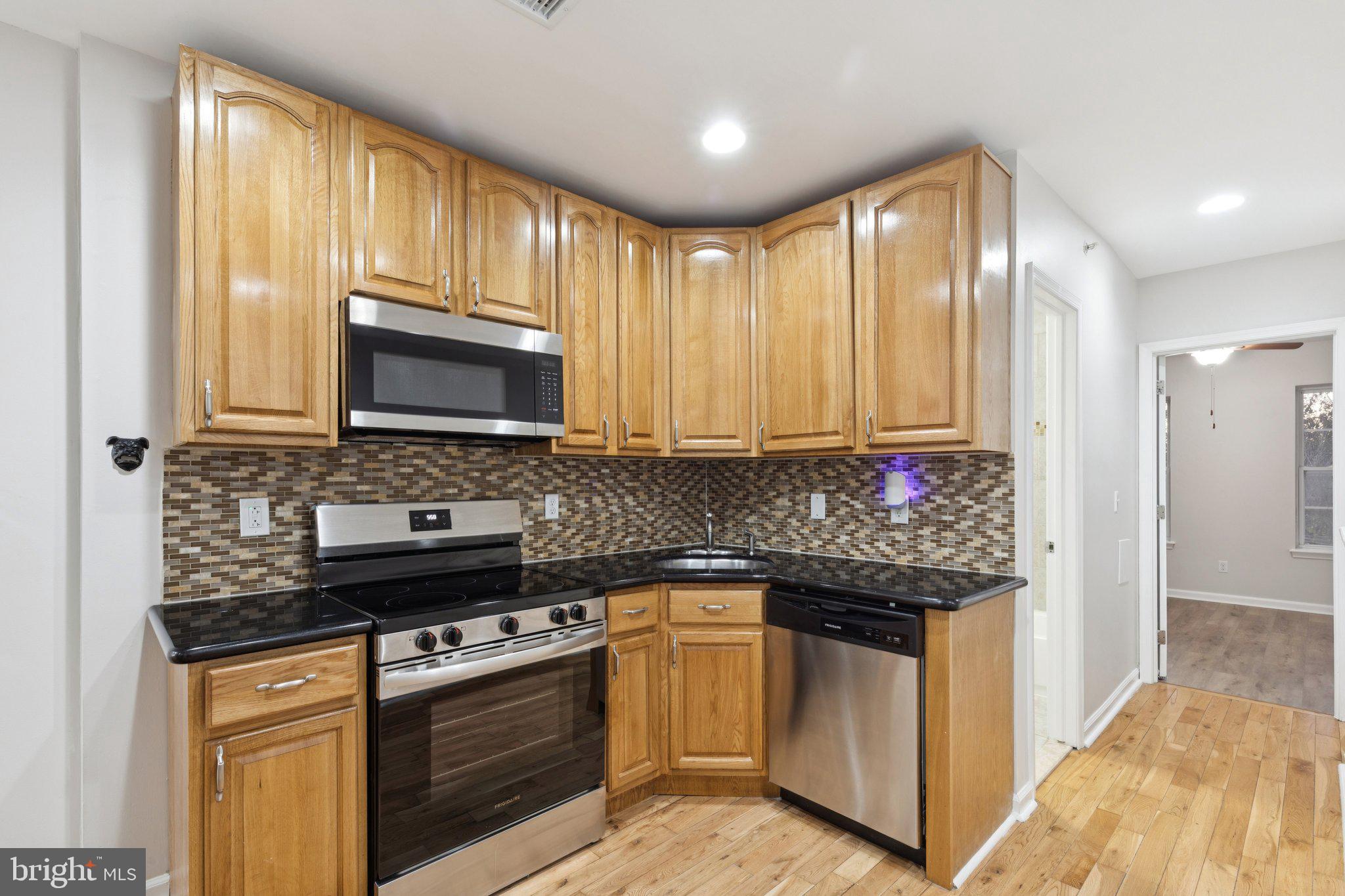 1931 North Uber Street, Unit 2 Philadelphia, PA 19121 - Photo 11 of 26 a kitchen with stainless steel appliances granite countertop a stove a sink and a microwave