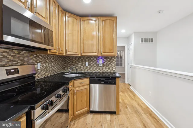 a kitchen with granite countertop a stove and a refrigerator