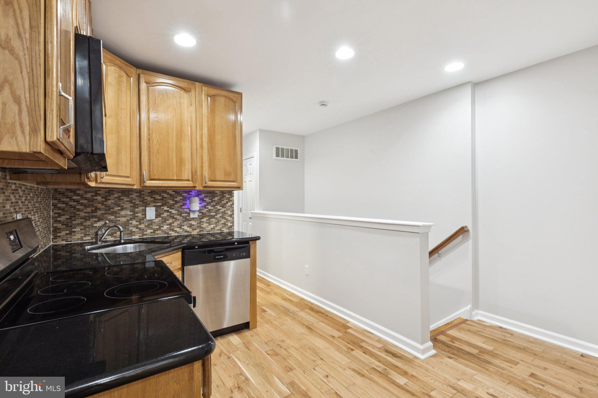 1931 North Uber Street, Unit 2 Philadelphia, PA 19121 - Photo 14 of 26 a kitchen with granite countertop a stove and a refrigerator