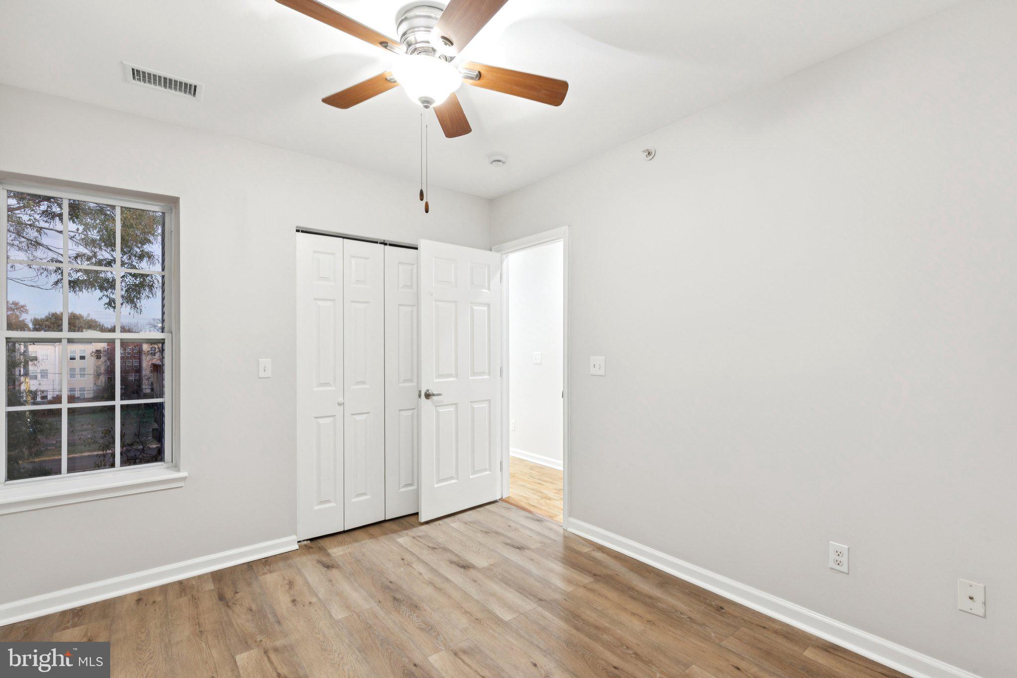 1931 North Uber Street, Unit 2 Philadelphia, PA 19121 - Photo 25 of 26 an empty room with chandelier fan and windows
