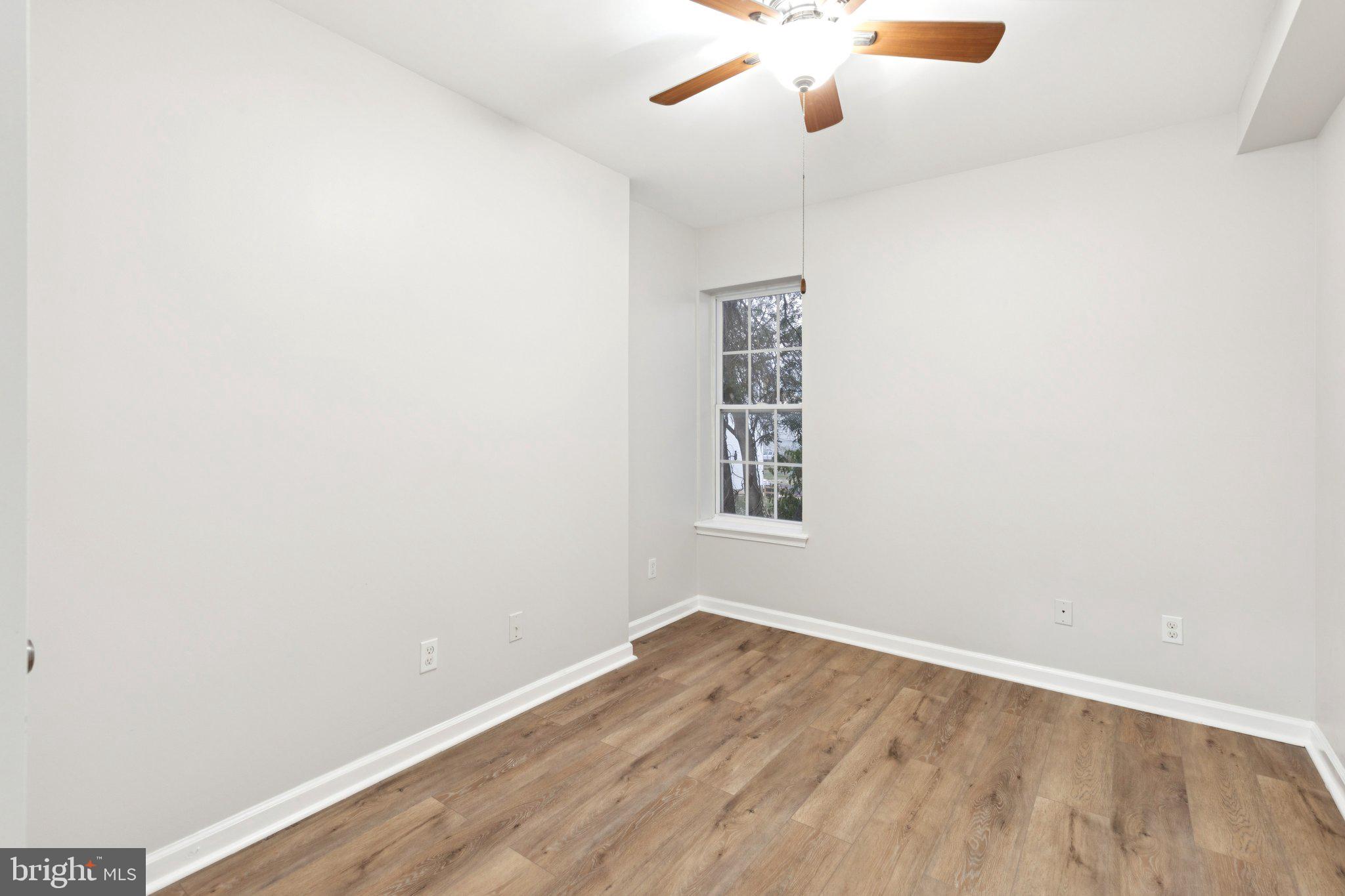 1931 North Uber Street, Unit 2 Philadelphia, PA 19121 - Photo 4 of 26 an empty room with wooden floor and windows