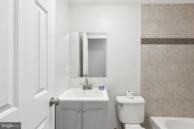 an empty room with wooden floor chandelier fan and windows